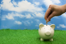 Person putting coins in piggy bank