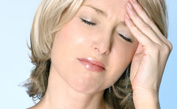 Woman with a headache rubbing forehead