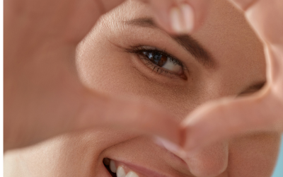 Person making a heart with hands over eye
